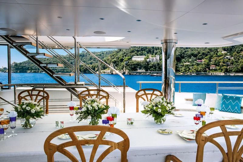 a table with chairs and flowers on it aboard LATONA Yacht for Sale