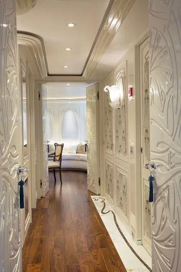 a hallway with a bed and a chair aboard LATONA Yacht for Sale