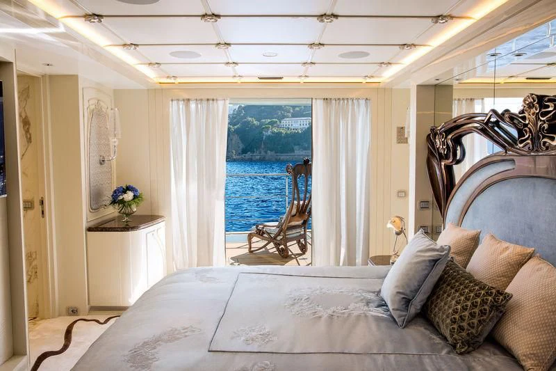 a bed with pillows and a chair aboard LATONA Yacht for Sale