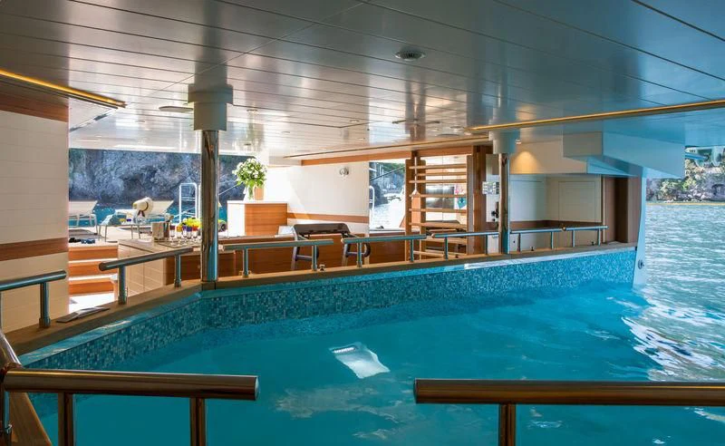 a swimming pool with a glass wall aboard LATONA Yacht for Sale