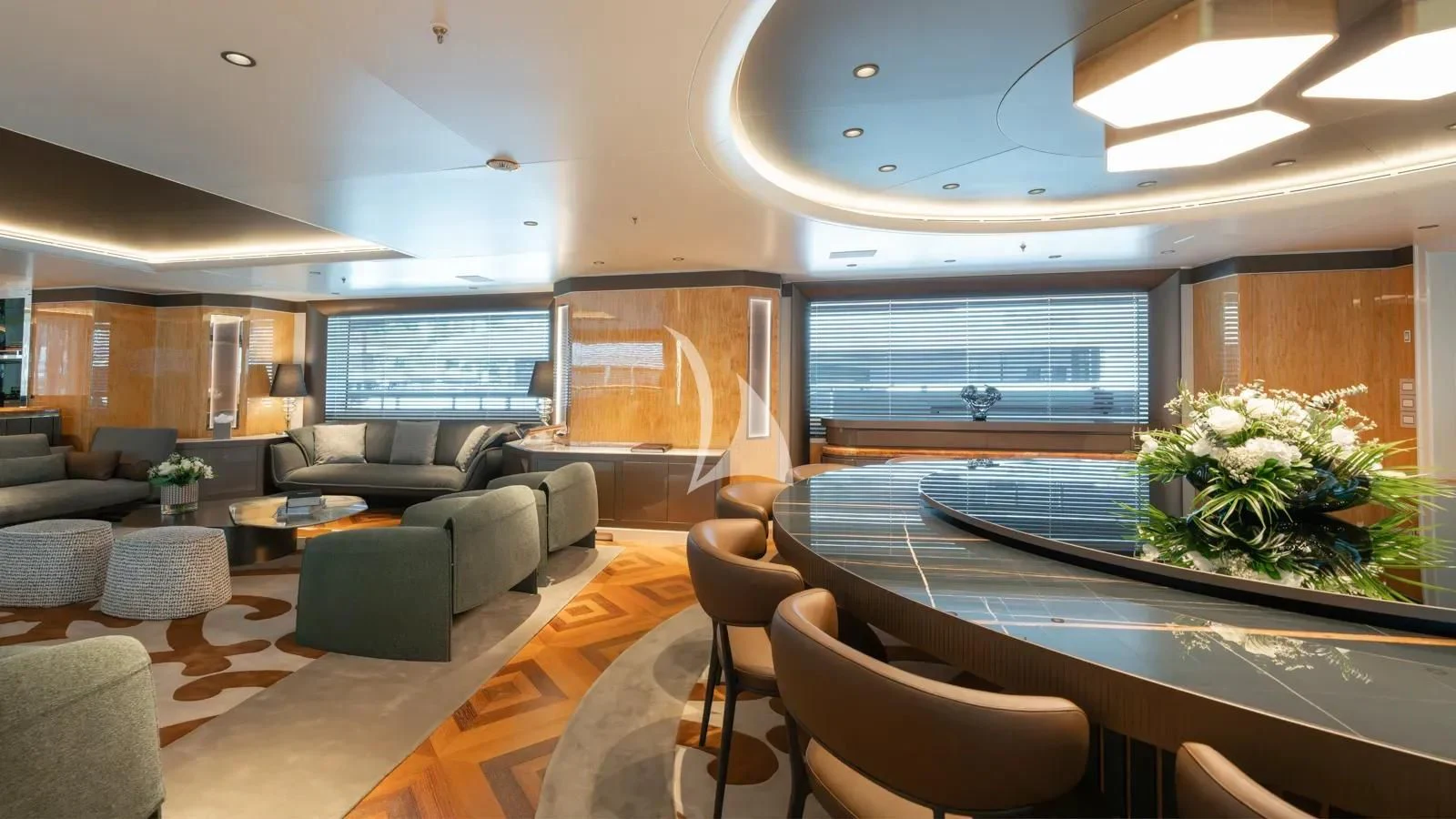 a large living room with a large glass table and a large window aboard AELIA Yacht for Sale