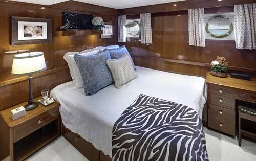 a bedroom with a bed and a desk aboard ASKARI Yacht for Sale