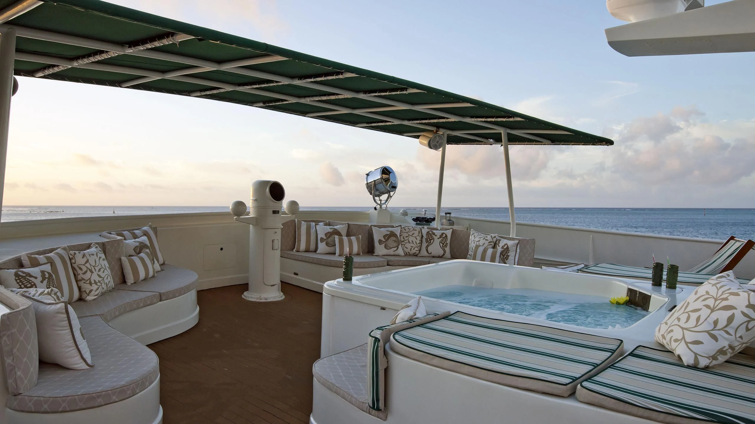 a lounge area with a large lounge chair and a large umbrella aboard ASKARI Yacht for Sale