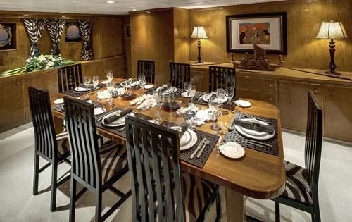 a dining room table set for a dinner party aboard ASKARI Yacht for Sale