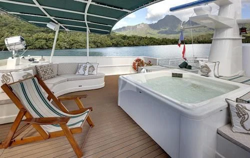 a room with a tub and chairs aboard ASKARI Yacht for Sale