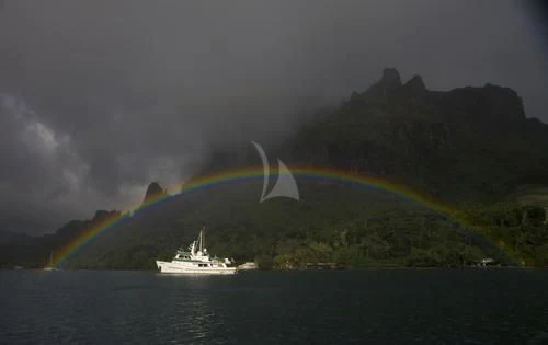 a boat in the water with a rainbow in the background aboard ASKARI Yacht for Sale