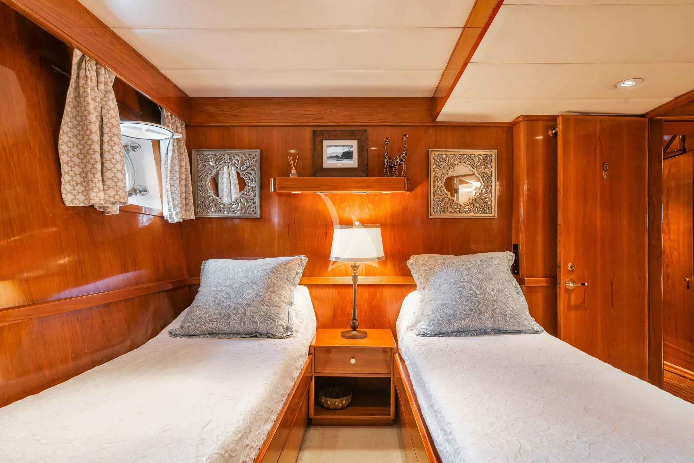 a bedroom with a bed and a lamp aboard ASKARI Yacht for Sale