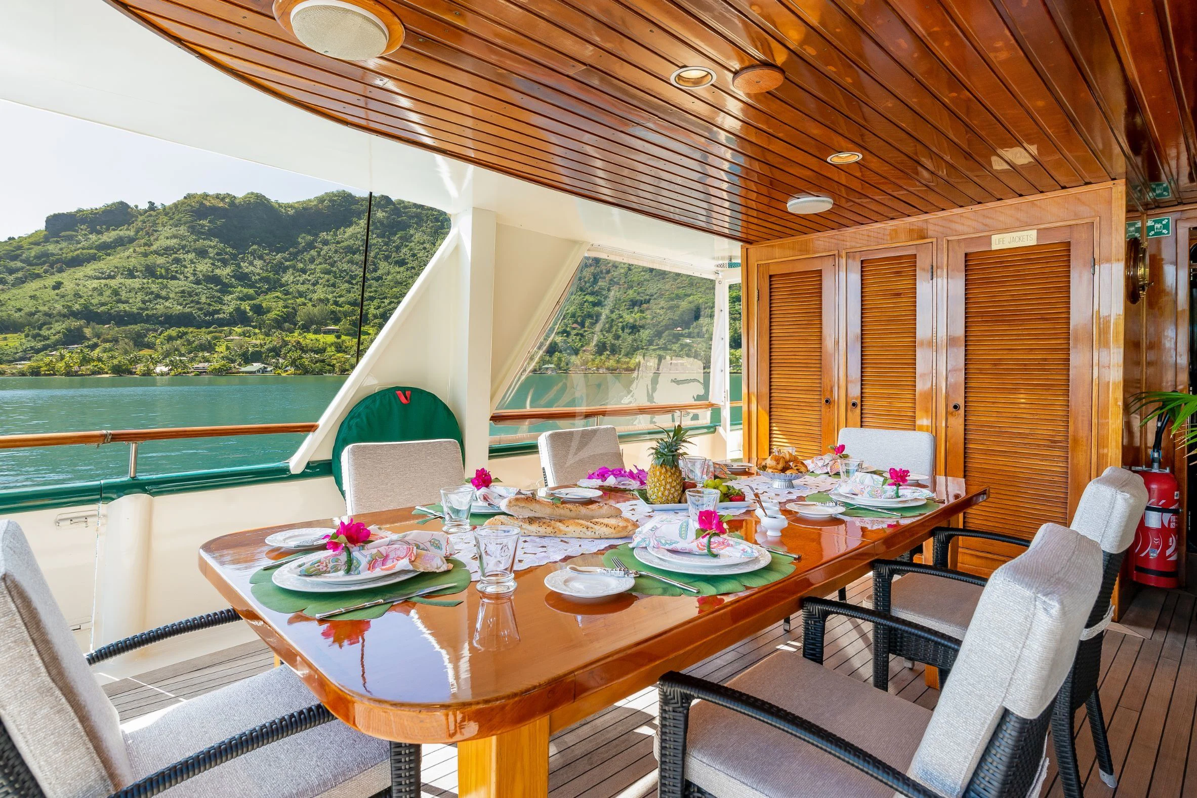 a table with chairs and a view of a mountain range aboard ASKARI Yacht for Sale