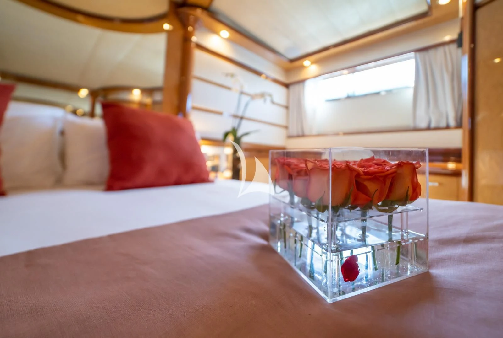 a table with a glass of wine and a bed in the background aboard IRMAO Yacht for Sale