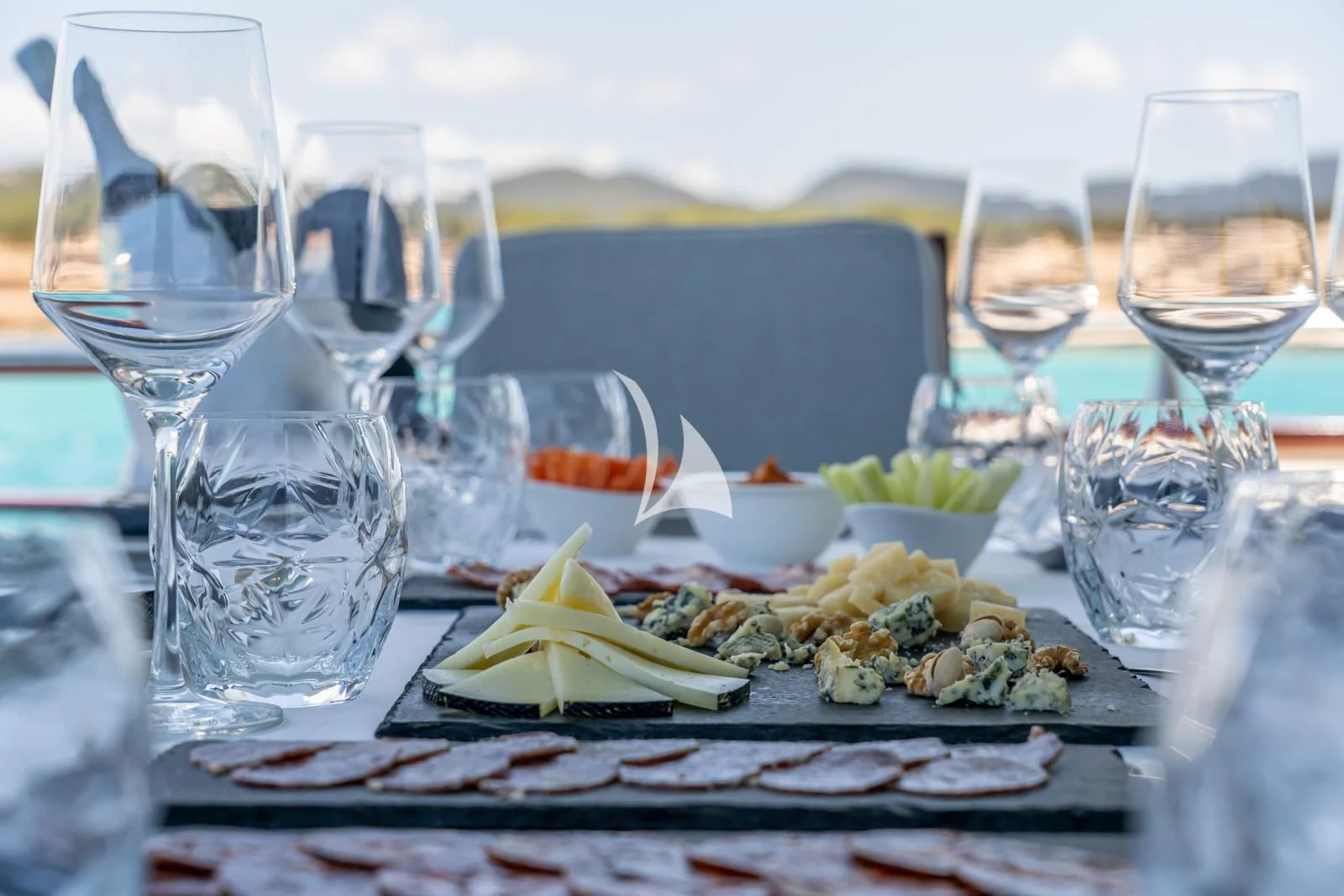 a plate of food and glasses on a table aboard IRMAO Yacht for Sale