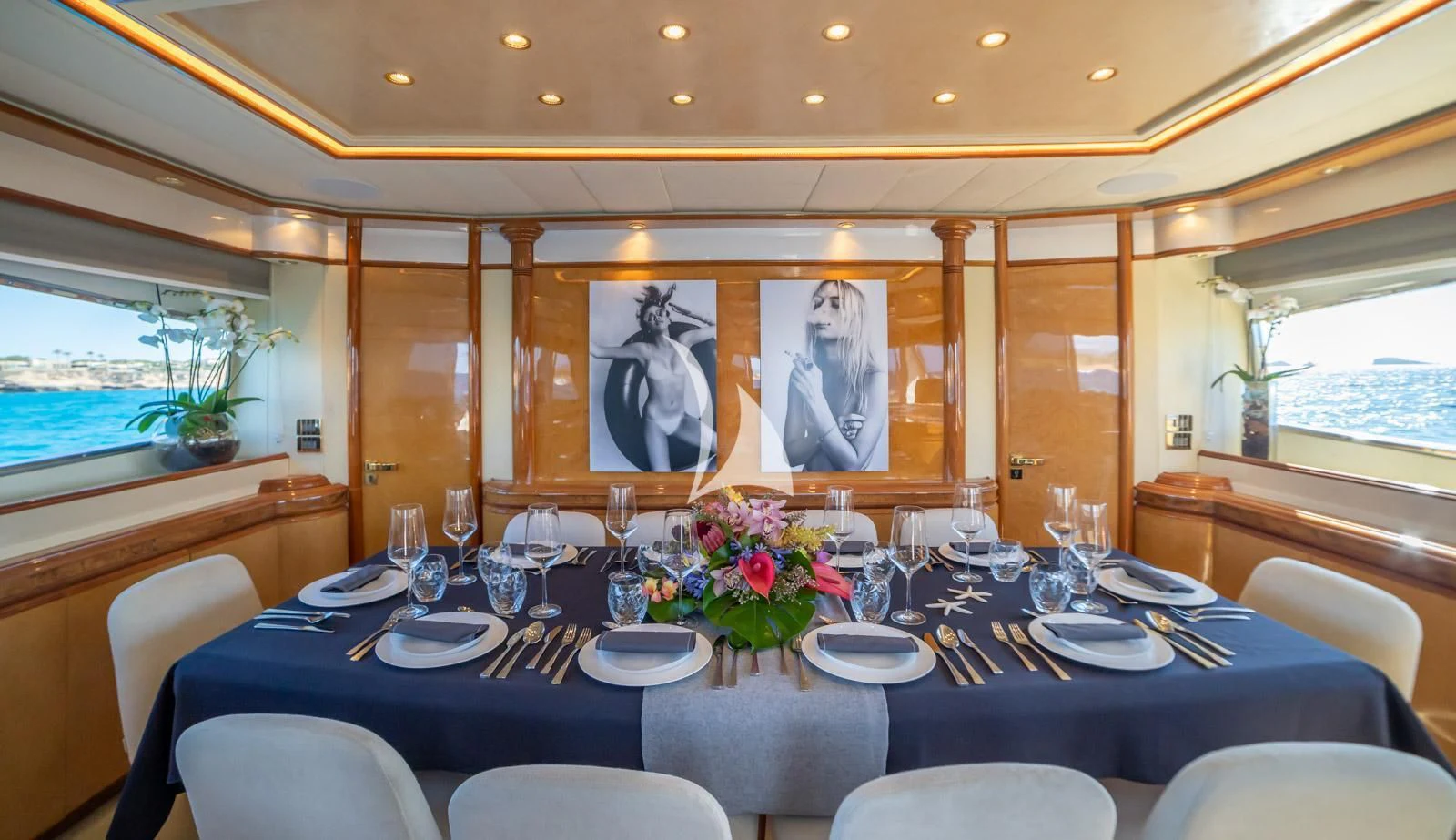 a dining room with a table set for a formal dinner aboard IRMAO Yacht for Sale