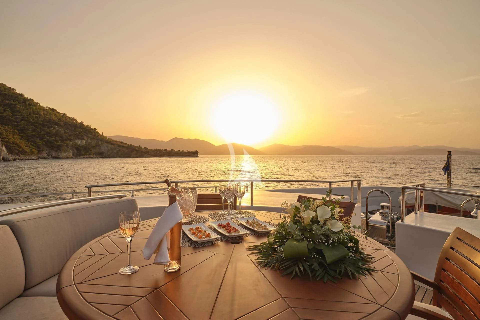 a table with plates and glasses on it by a body of water aboard ELENA V Yacht for Sale