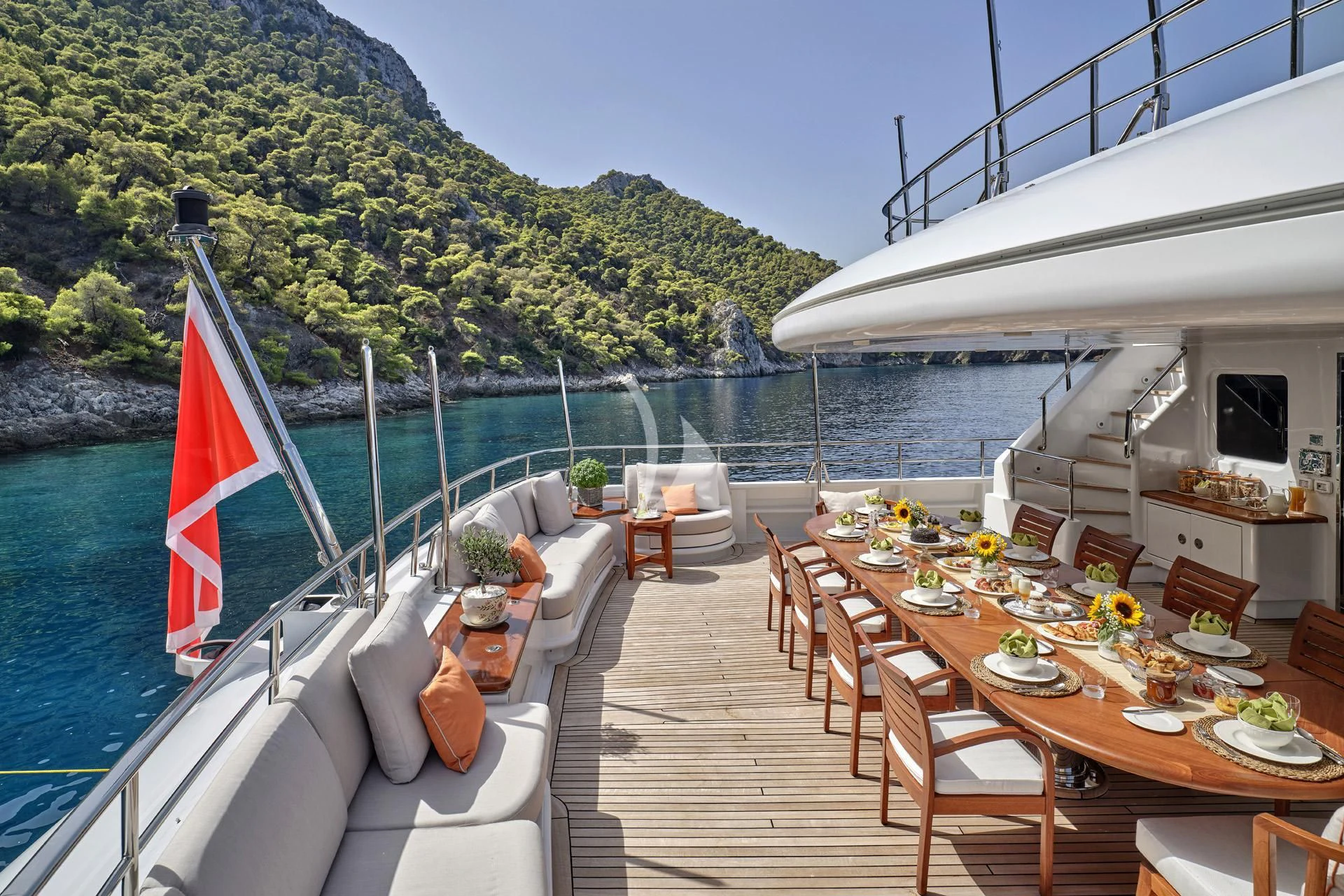 a deck with tables and chairs on it next to a body of water aboard ELENA V Yacht for Sale