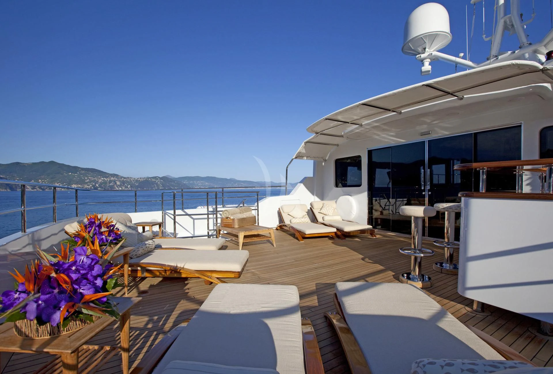 a deck with a view of the ocean and a boat aboard ELENA V Yacht for Sale