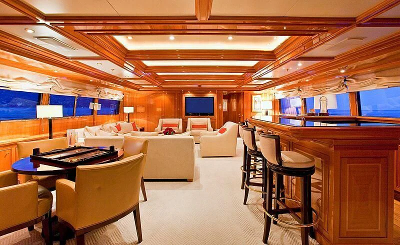 a room with tables chairs and a television aboard ELENA V Yacht for Sale