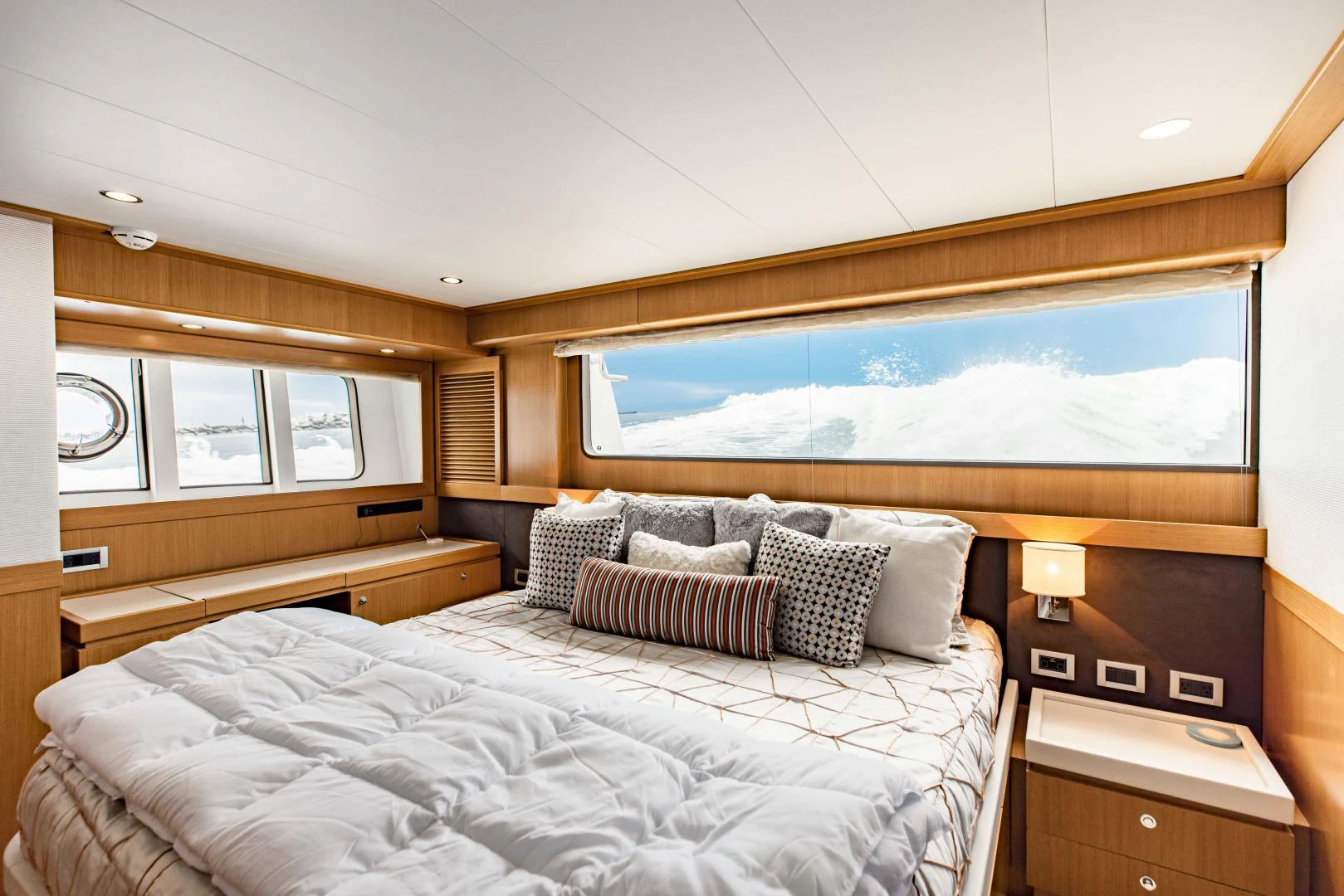 a bed with a painting on the wall aboard SHE RUNS WET Yacht for Sale