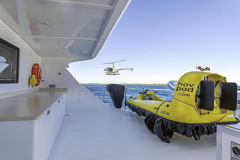a green and yellow tractor on a deck of a ship aboard CHARLEY Yacht for Sale