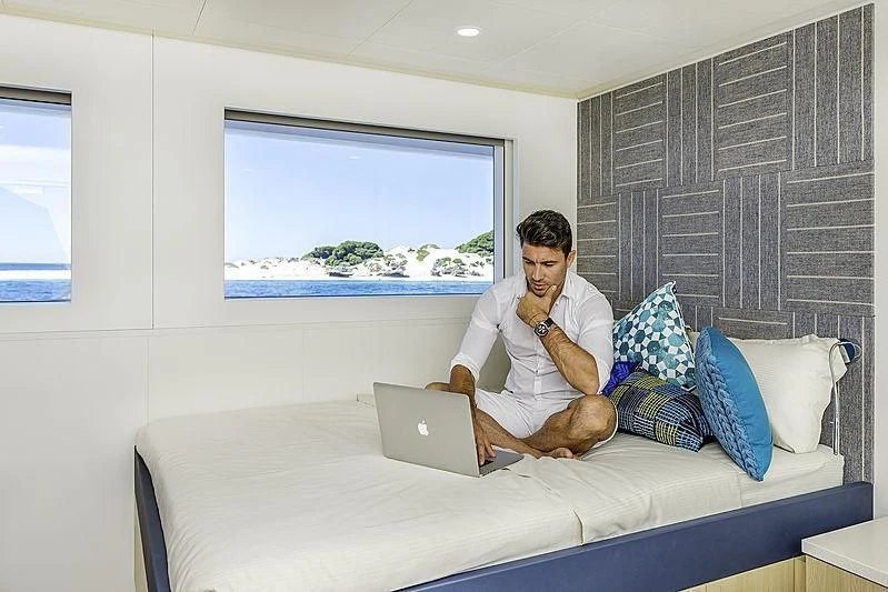 a person sitting on a couch with a laptop aboard CHARLEY Yacht for Sale