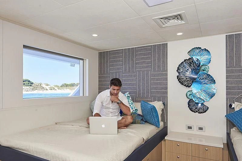 a person sitting in a hospital bed with a laptop and a stuffed animal aboard CHARLEY Yacht for Sale