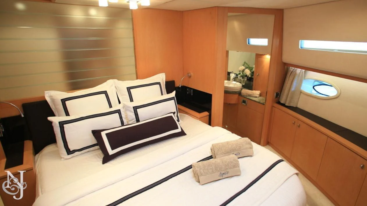 a bed with white sheets and pillows aboard SOPHIA Yacht for Sale