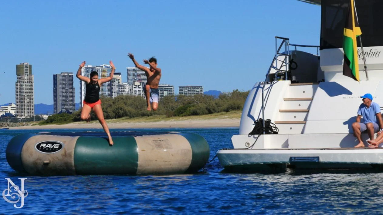 a couple of people jumping off a boat into the water aboard SOPHIA Yacht for Sale