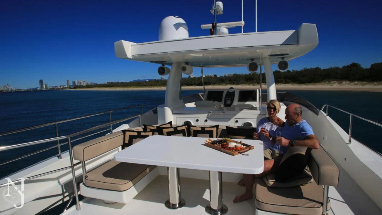 a couple of people sitting on a boat with a pizza in the water aboard SOPHIA Yacht for Sale