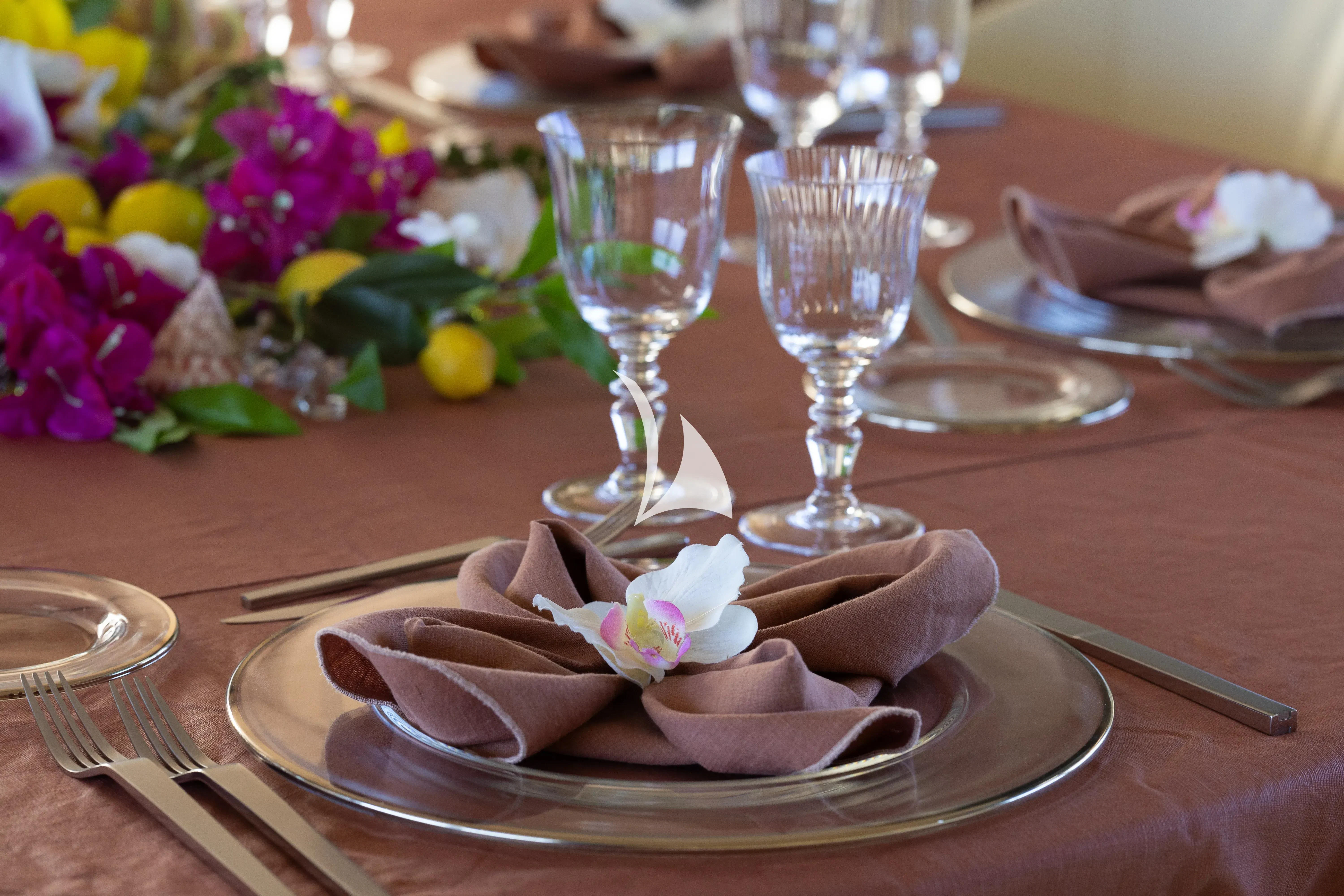 a table with a plate of food and glasses on it aboard ASLEC 4 Yacht for Sale