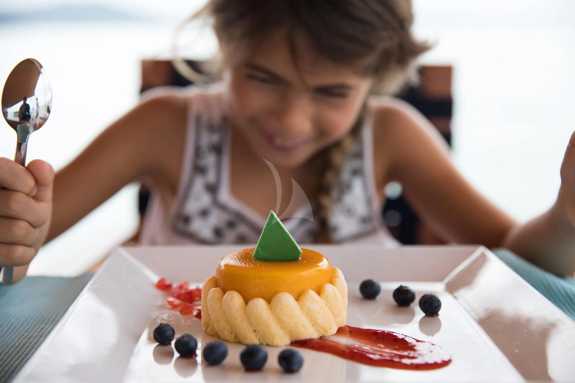 a girl eating a cake aboard THE BLUE Yacht for Sale