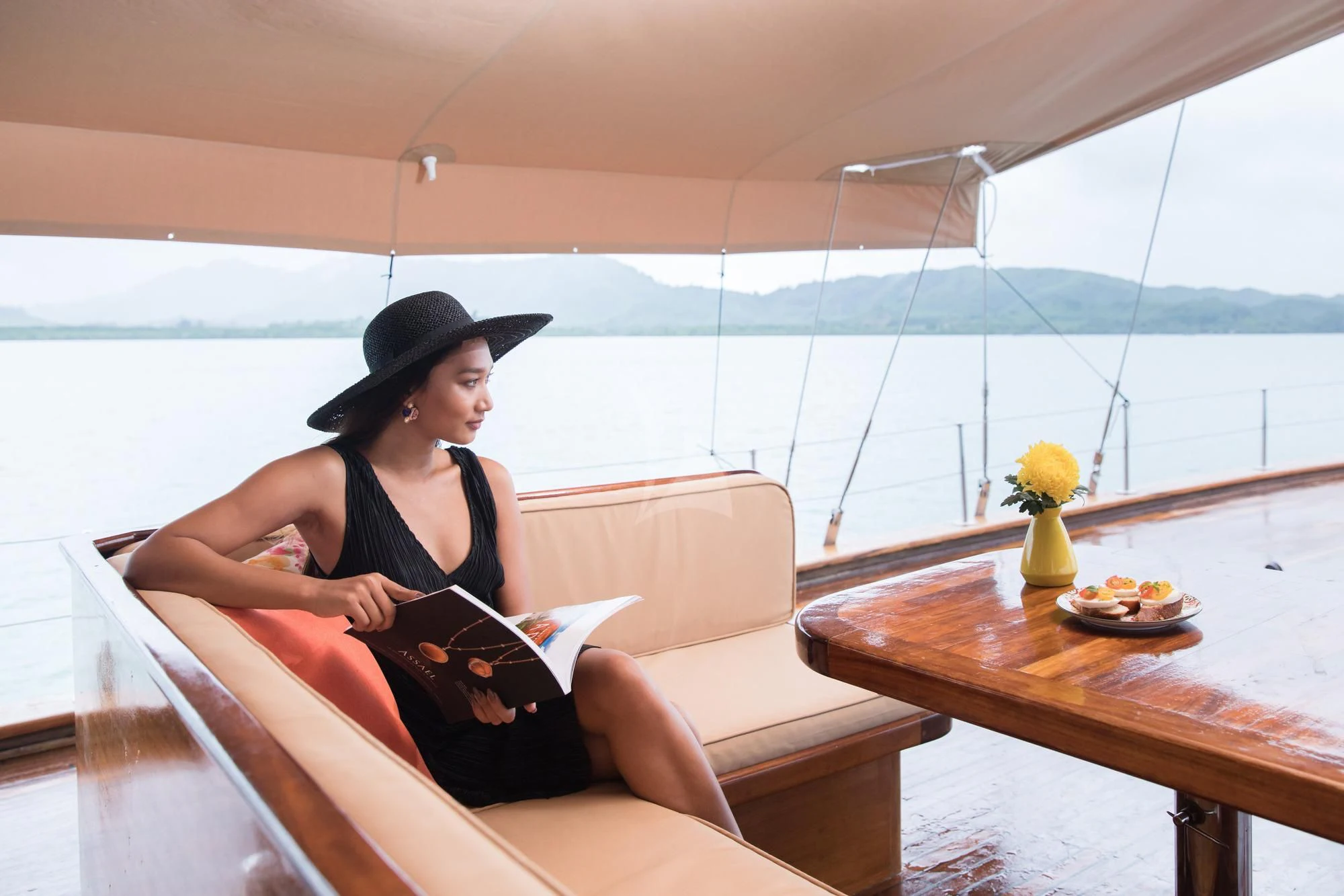 a woman sitting on a couch reading a book aboard THE BLUE Yacht for Sale