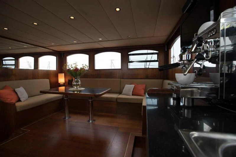a living room with a table and couches aboard THE BLUE Yacht for Sale