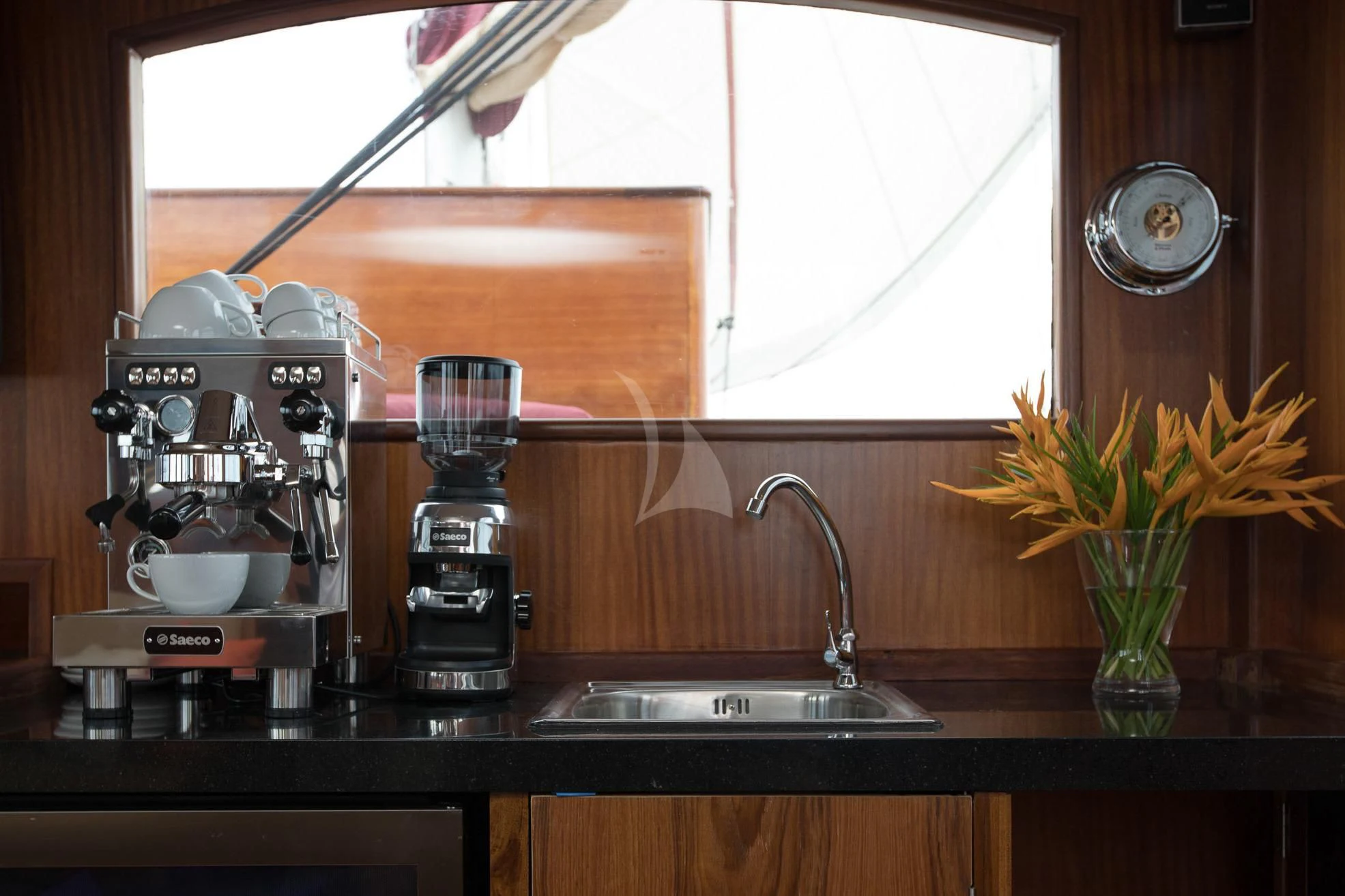a kitchen counter with a coffee maker and a vase with flowers aboard THE BLUE Yacht for Sale