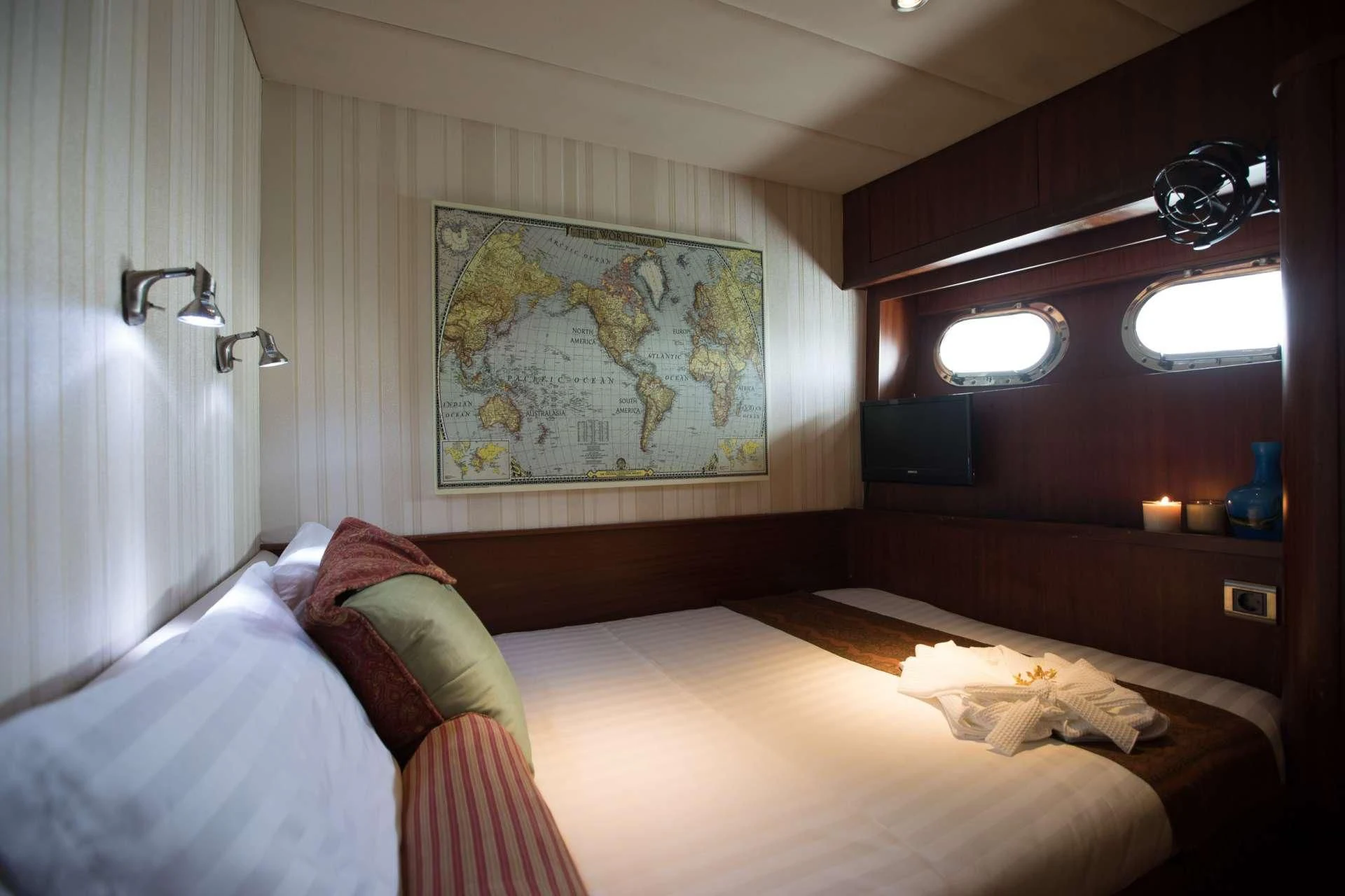a room with a bed and a painting on the wall aboard THE BLUE Yacht for Sale