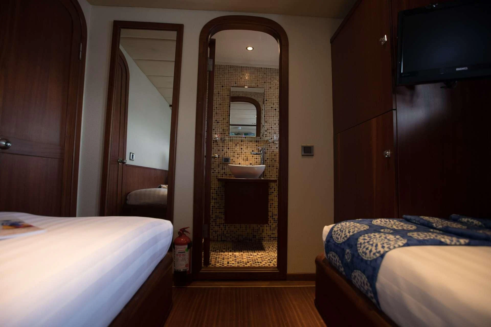 a bedroom with a bed and a television aboard THE BLUE Yacht for Sale
