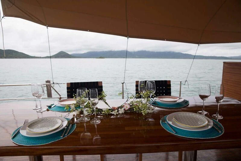 a table with plates and glasses on it aboard THE BLUE Yacht for Sale