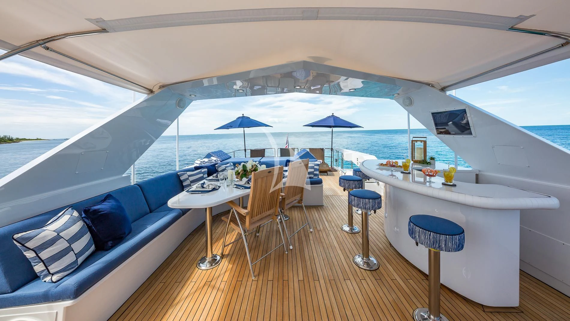 a large white tent with a table and chairs and umbrellas aboard DESTINY Yacht for Sale