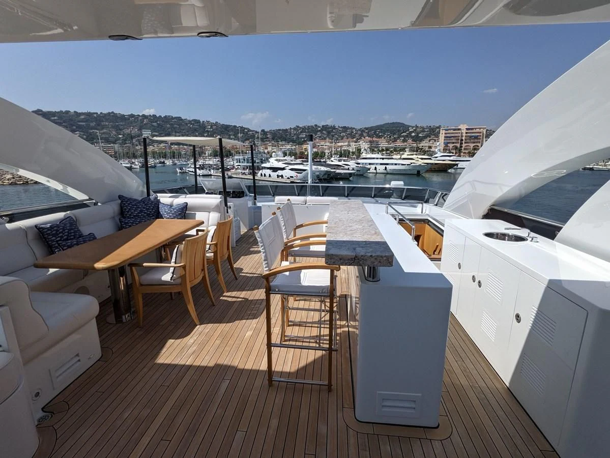 a deck with chairs and a table on it aboard MORDAN Yacht for Sale