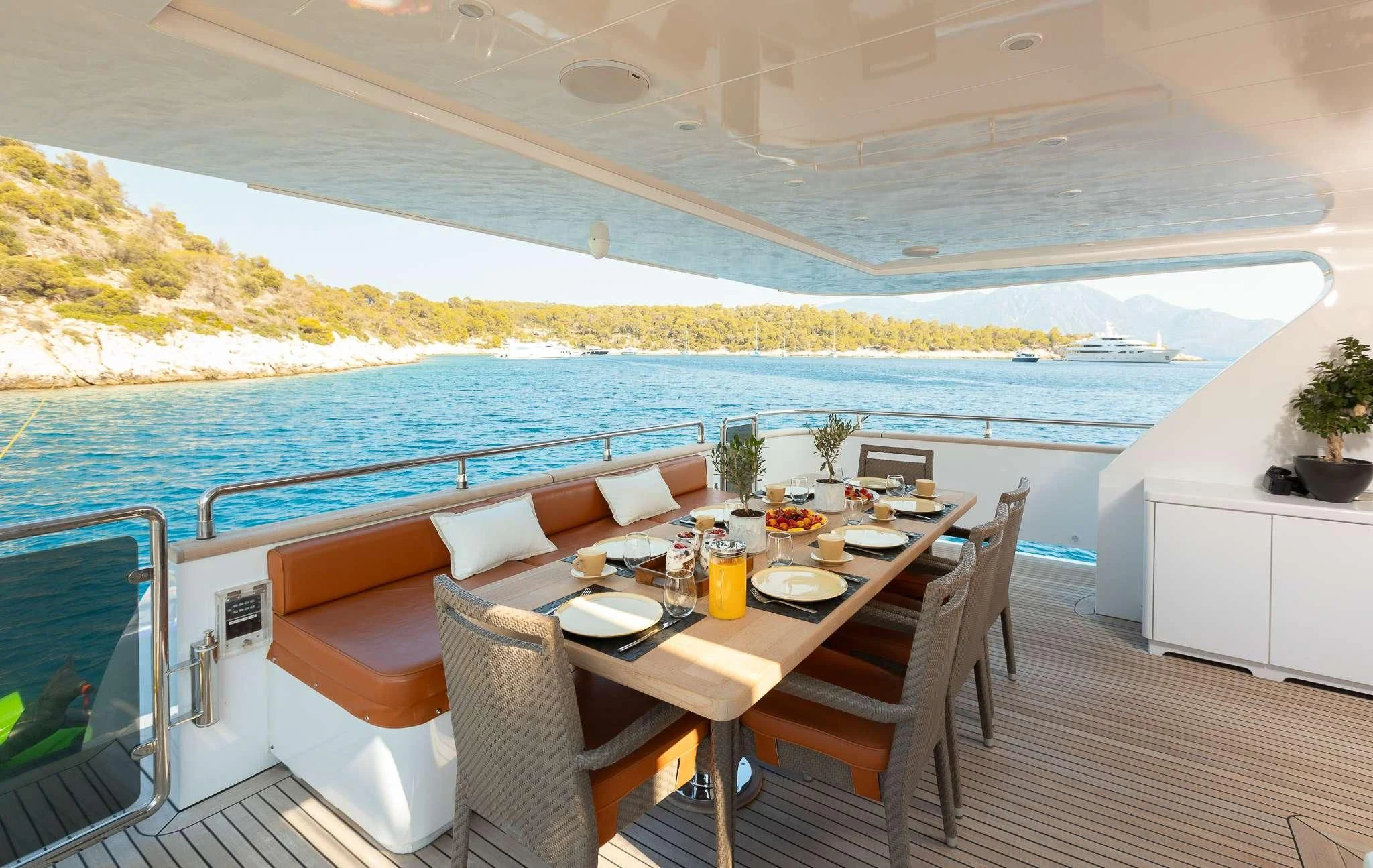 a table on a deck with chairs and a view of the ocean aboard GIOE I Yacht for Sale