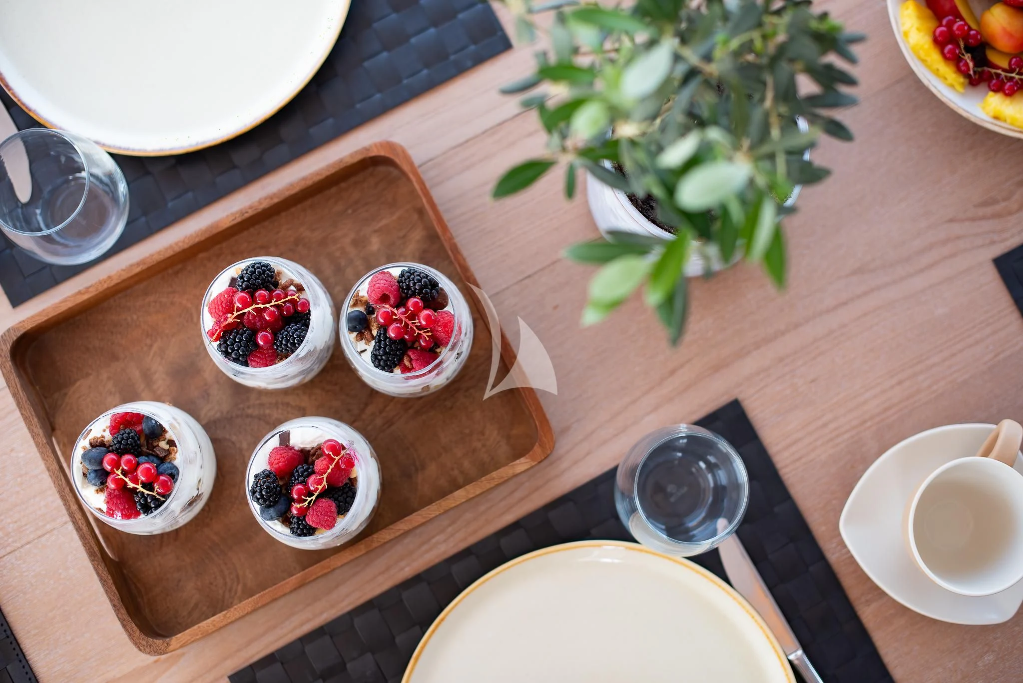 a table with plates and cups of food on it aboard GIOE I Yacht for Sale