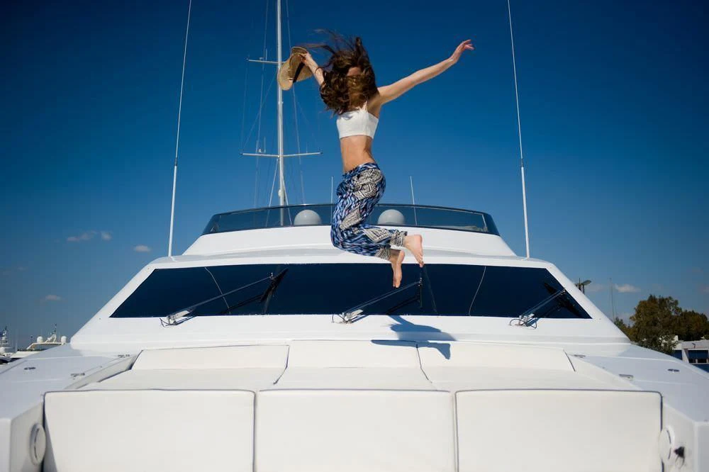 a man jumping off a white car aboard GIOE I Yacht for Sale