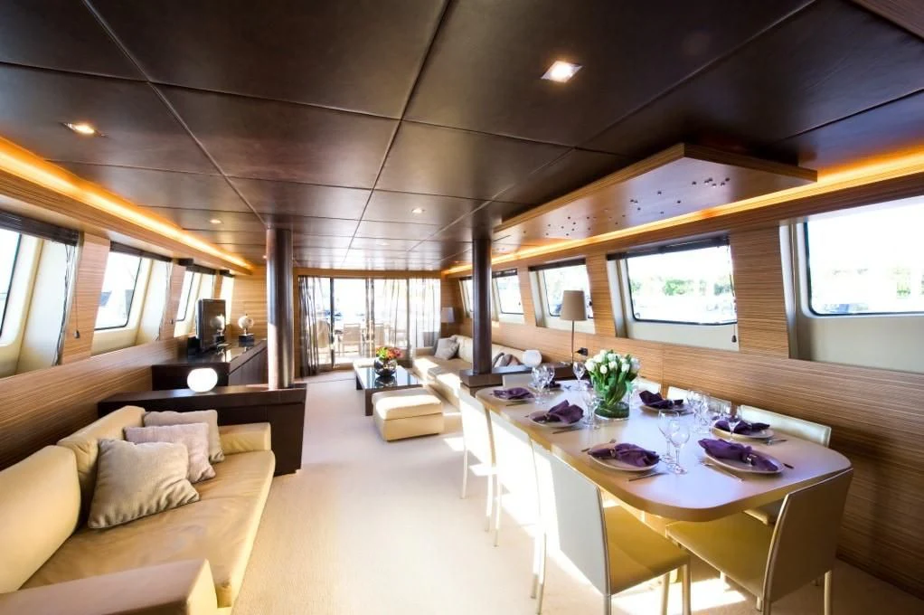 a room with a table and chairs aboard GIOE I Yacht for Sale