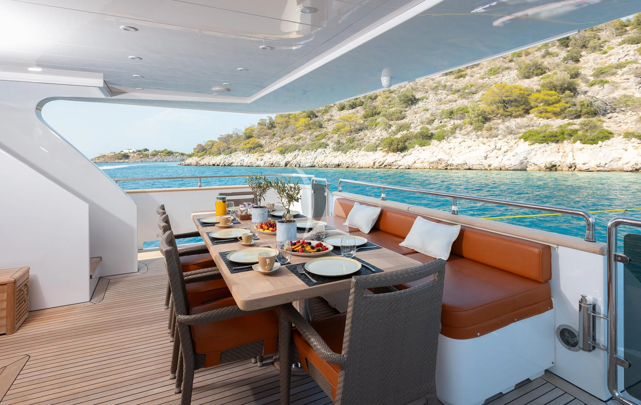 a table with chairs and a view of a body of water aboard GIOE I Yacht for Sale