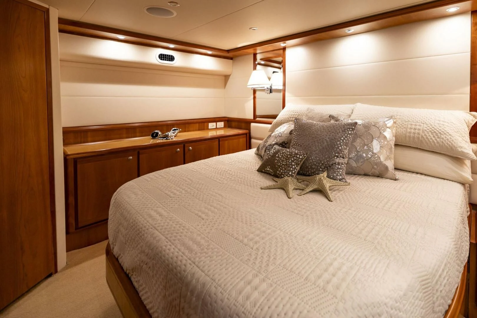 a bed with a white comforter and pillows aboard REEL BUSY Yacht for Sale