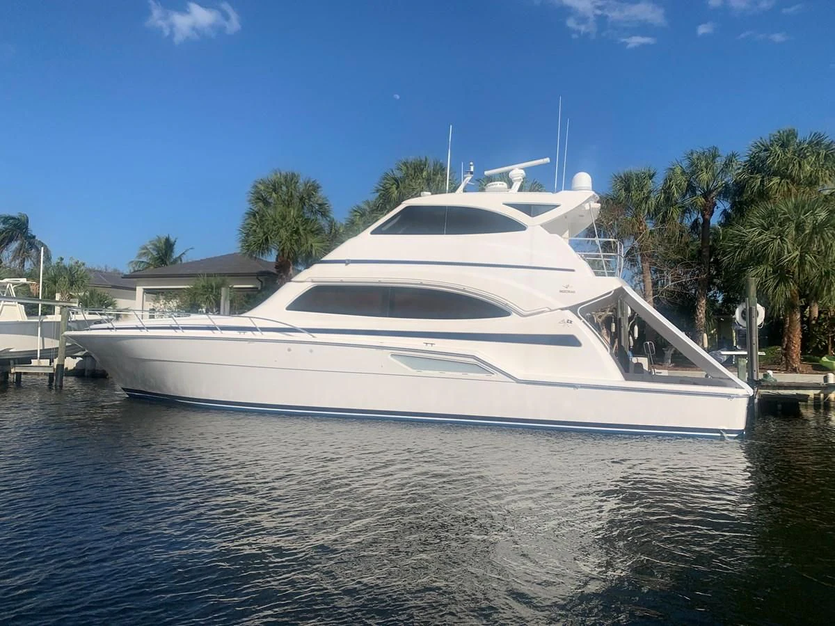 a white yacht docked at a dock aboard REEL BUSY Yacht for Sale