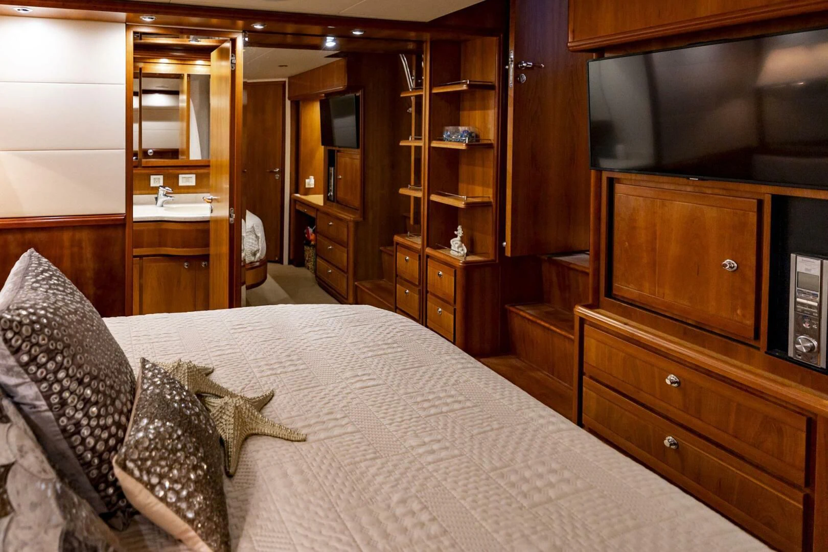 a bedroom with a bed and a dresser aboard REEL BUSY Yacht for Sale