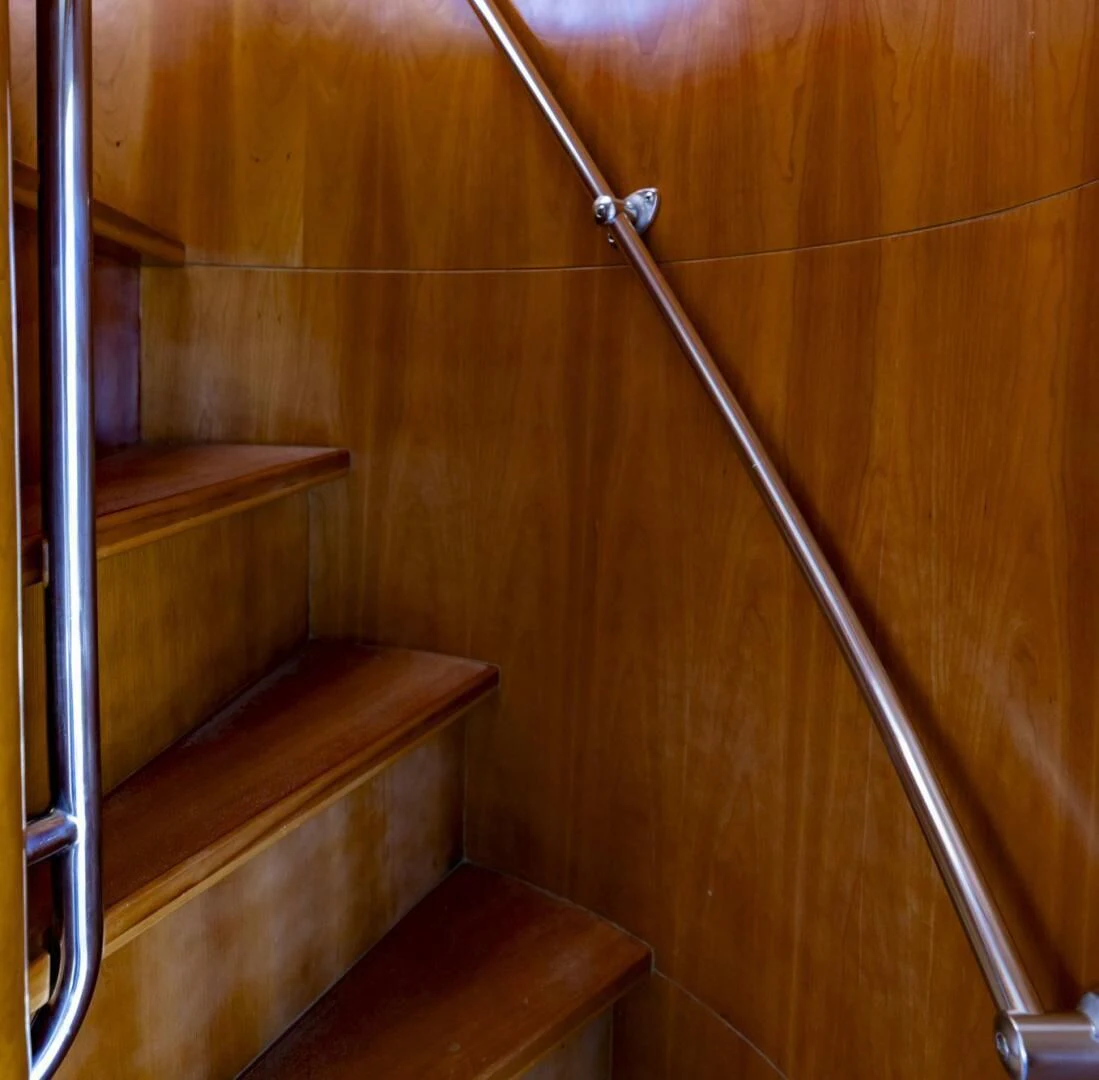 a wooden staircase with a metal railing aboard REEL BUSY Yacht for Sale