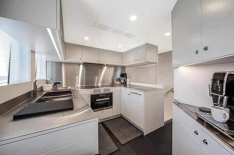 a kitchen with white cabinets aboard JANGADA Yacht for Sale