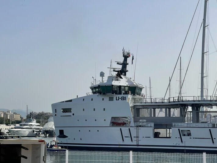 a large white boat in a harbor aboard WINGMAN Yacht for Sale