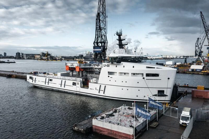a large white boat in a harbor aboard WINGMAN Yacht for Sale