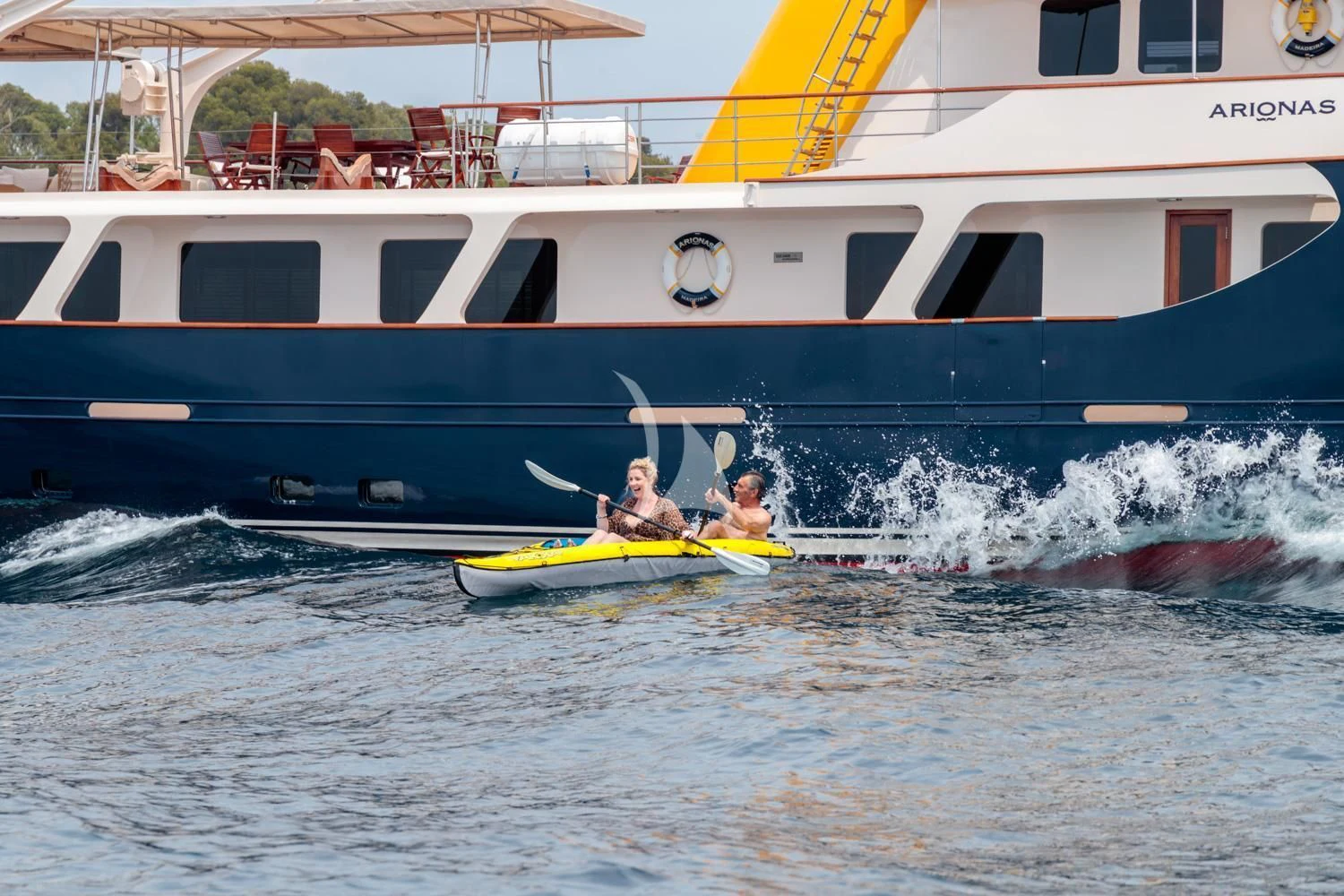 a couple of people in a yellow kayak in the water aboard ARIONAS Yacht for Sale