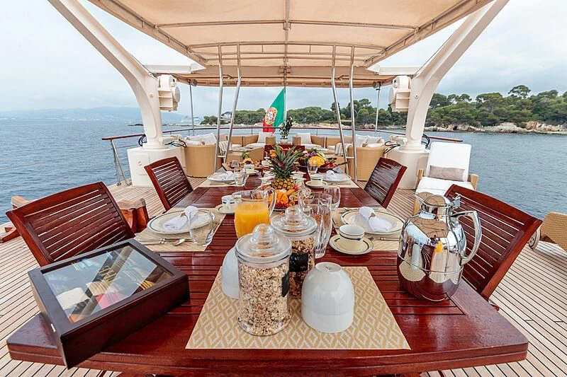a table with plates and food on it aboard ARIONAS Yacht for Sale